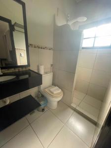 a bathroom with a toilet and a sink and a mirror at Villa Veríssimo in Jericoacoara