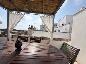 a wooden table and chairs on a balcony at Casa Ulivo in Ostuni
