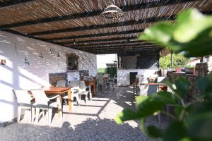 a patio with tables and chairs under a wooden roof at Rijeka Pansiyon in Ayvalık