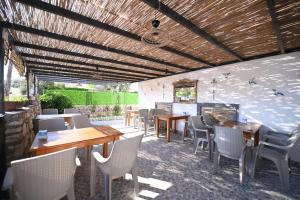 a patio with tables and chairs and a fireplace at Rijeka Pansiyon in Ayvalık