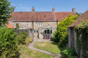 an exterior view of a house with a yard at Eighteen Pottergate in Helmsley