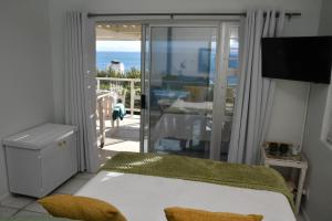 a bedroom with a bed and a view of the ocean at Amazing Grace B&B in Gansbaai +99 photos