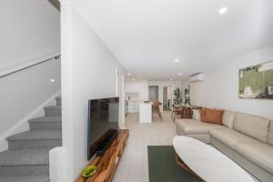 a living room with a couch and a tv at Breakwall Retreat in Manning Point