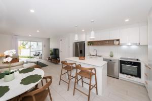a kitchen and living room with a table and chairs at Breakwall Retreat in Manning Point