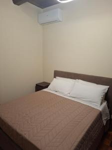 a bedroom with a bed with a brown blanket and white pillows at B&B Dimora D'Alfano in SantʼAngelo in Pontano