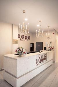 a lobby with a reception desk with flowers and chandeliers at Salis Hotel & Medical Spa in Turda
