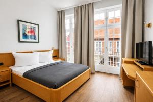 a hotel room with a bed and a television at Hotel Borchers in Celle