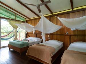 a bedroom with two beds with drapes over them at Hotel Finca Maresia in Drake +122 photos