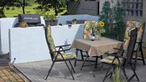 a table and chairs on a patio with a table and a laptop at Relax House in Dommitzsch