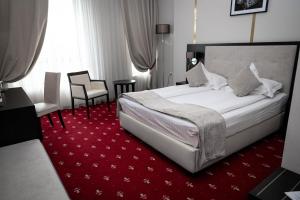 a hotel room with a bed and a red carpet at Salis Hotel & Medical Spa in Turda +40 photos