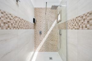 a bathroom with a shower with a glass door at Domus dell'Angelo in Monte SantʼAngelo