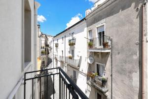 an alley of buildings with potted plants on balconies at Domus dell'Angelo in Monte SantʼAngelo
