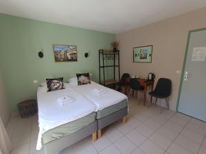 a bedroom with a bed and a table and chairs at Hotel Rêve de la Vallée in Blesle