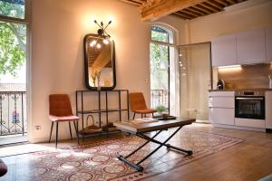 a living room with a table and two chairs at Elegant apartment with balcony - Maison Comte in Uzès