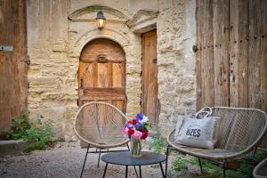 two chairs and a table with a vase of flowers at Elegant apartment with balcony - Maison Comte in Uzès