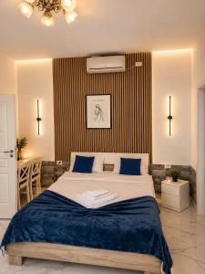 a bedroom with a large bed with blue pillows at AFY STAYS Boutique Apartments in Bucharest