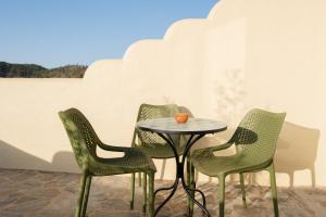 four chairs and a table and a table and chairs at Vida Pura Guesthouse in Odeceixe