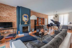 a living room with a couch and a brick wall at Maison Bacchus 31 in Buzet-sur-Tarn