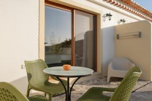 a patio with a table and chairs and a window at Vida Pura Guesthouse in Odeceixe +70 photos