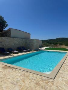 a swimming pool in front of a house at Hidden Villa in Klarići