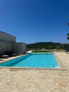 a swimming pool in front of a house at Hidden Villa in Klarići
