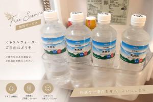 a group of four bottles of water in a refrigerator at SaKuRa B&B in Sakura