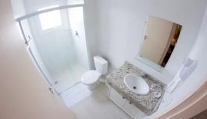 a white bathroom with a sink and a shower at Hotel Toyo Inn in Boituva +27 photos