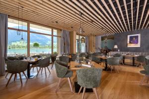 a restaurant with tables and chairs and a large window at Das Lakeside - Move&Relax in Walchsee