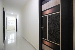 a black door in a hallway with a white wall at Collection O Stayo in Hyderabad