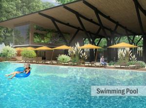 Eine Person schwimmt mit einem Sonnenschirm in einem Schwimmbecken in der Unterkunft Nuvali Sta Rosa Laguna in Pulong Cacawate
