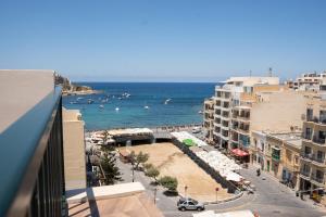 a view of a beach and the ocean from a building at Electra Residence - Central Duplex Penthouse in Marsalforn
