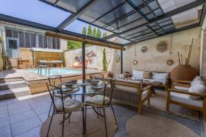 a patio with a table and chairs and a pool at Maison Bacchus 31 in Buzet-sur-Tarn