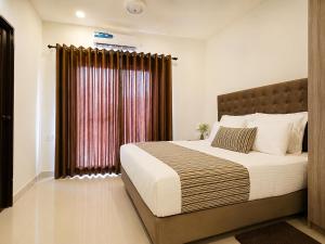 a bedroom with a large bed and a window at Signature 2BR - Deluxe - Santorini - Negombo in Negombo
