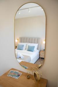 a bedroom with a bed and a large mirror at Electra Residence - Central Duplex Penthouse in Marsalforn