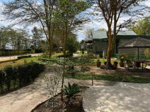 a garden with a table and trees and a building at Lala Inn in Gilgil +6 photos