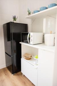 a kitchen with a black refrigerator and white cabinets at Cazorla a tus pies, en pleno centro con parking in Cazorla +14 photos