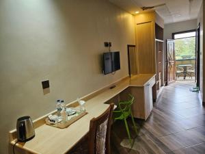 a room with a table and a tv on the wall at Lala Inn in Gilgil