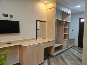 an office with a desk with a tv on a wall at Lala Inn in Gilgil