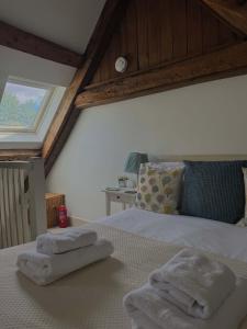 a bedroom with a bed with two towels on it at Stunning stone cottage on Bath's doorstep in Box