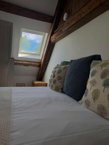 a bedroom with a white bed with a window at Stunning stone cottage on Bath's doorstep in Box