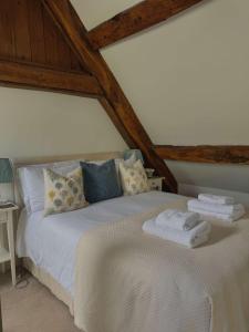 a bedroom with a bed with towels on it at Stunning stone cottage on Bath's doorstep in Box