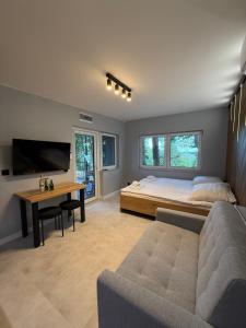 a bedroom with a bed and a desk and a tv at Turawa Lake Residence in Turawa