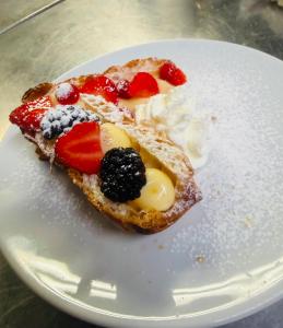 a piece of toast with fruit on a white plate at Hotel Merano in Misano Adriatico