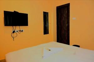 a bedroom with a bed with a tv on the wall at Galaxy Stellar Suites in kolkata +27 photos