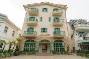a large white building with green doors and windows at dei Balconi Dalat in Ấp Ða Lợi