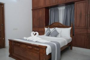 a bed with a white ribbon on top of it at Cosy Concepts in Kovalam