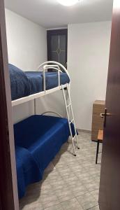 a room with a bunk bed with blue sheets and a ladder at Dolce Rifugio in Siculiana