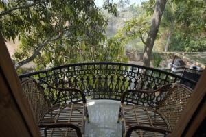 a bench sitting on a porch with a table at Cosy Concepts in Kovalam +2 photos