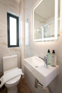 a white bathroom with a sink and a toilet at Electra Residence - Central Duplex Penthouse in Marsalforn +37 photos
