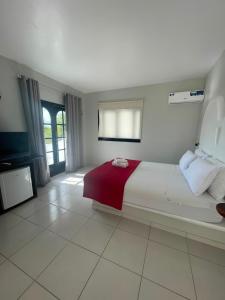 a bedroom with a large bed with a red blanket at Villa Veríssimo in Jericoacoara